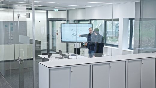 Personen bei der Entwicklung individueller Produktkonzepte anhand von Skizzen und technischen Unterlagen