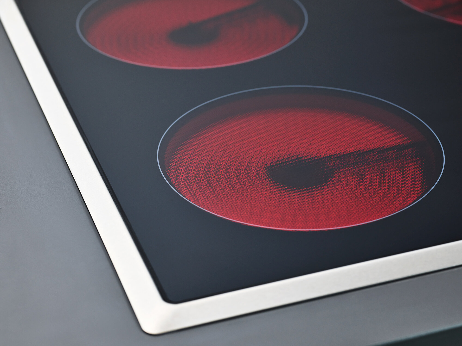 Glaskeramik-Kochfeld mit rot leuchtenden Heizspulen 