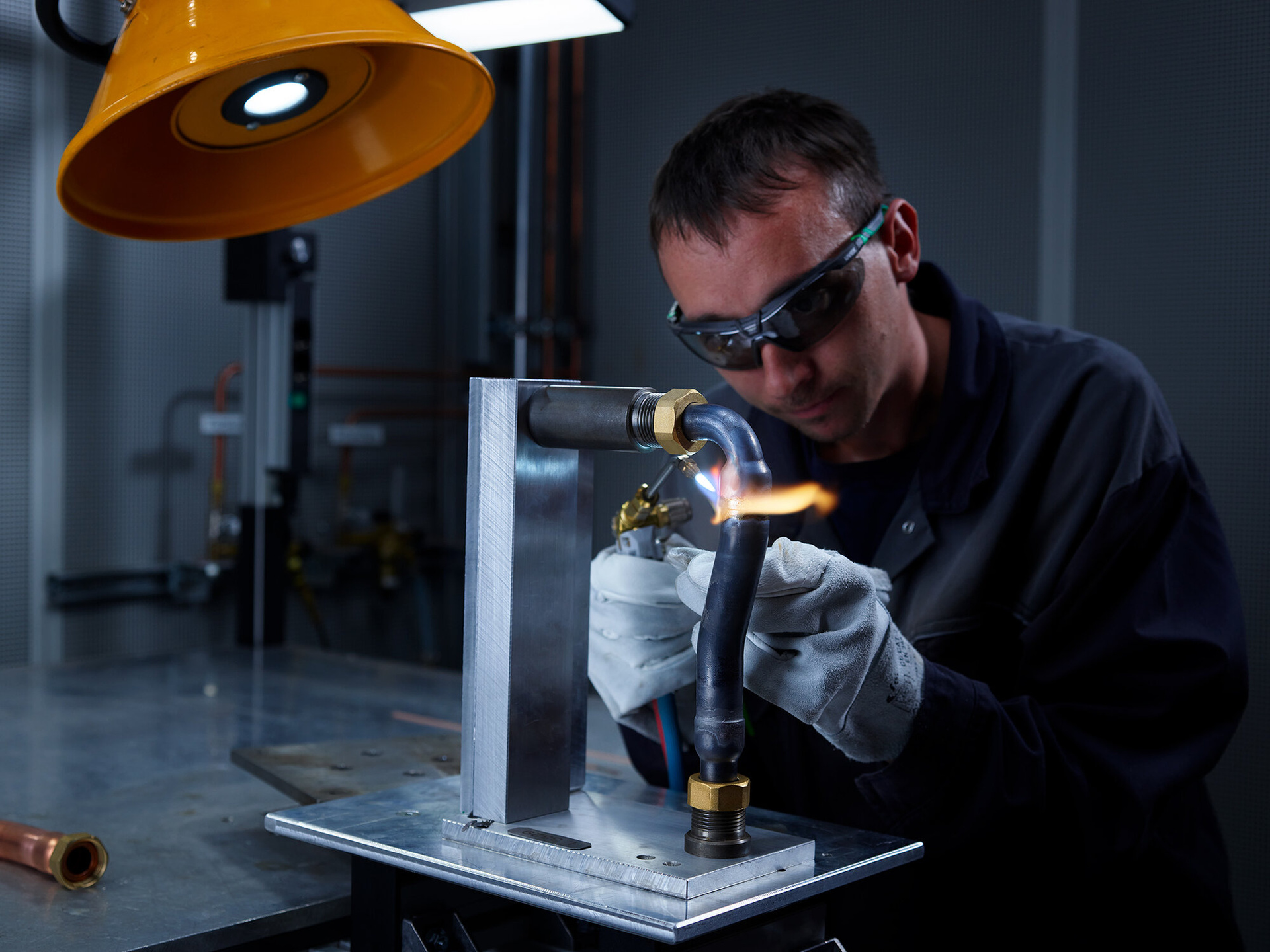 Industriemitarbeiter beim präzisen Hartlöten von Kupfer-Edelstahl-Verbindungen